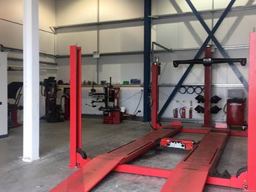 The workshop floor with the red alignment ramp and tyre machines