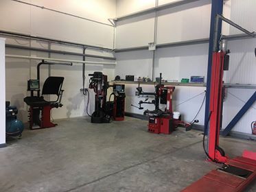 The tyre changer and wheel balancer beside the alignment ramp